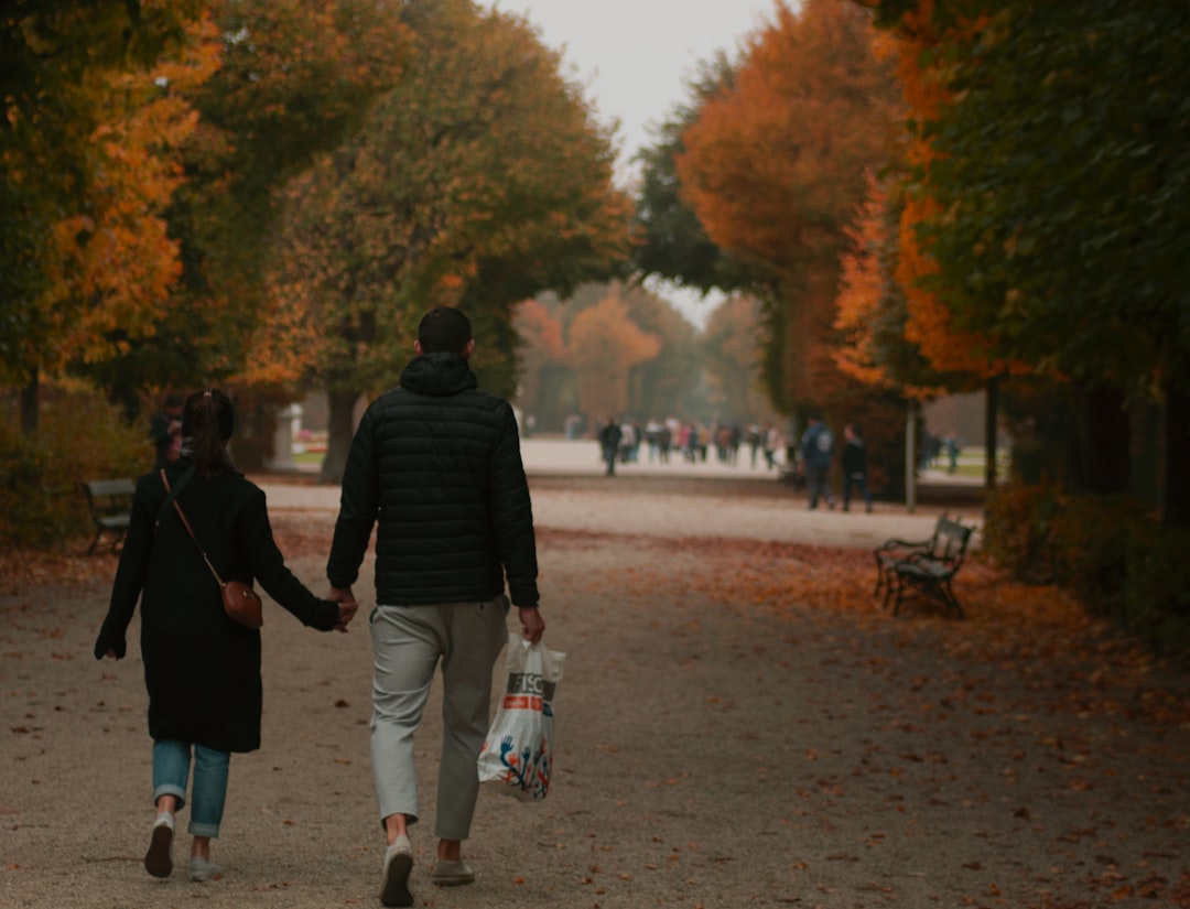 man and woman walking on gray concrete road during daytime