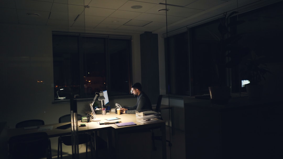 Man working late at a dimly lit office desk.