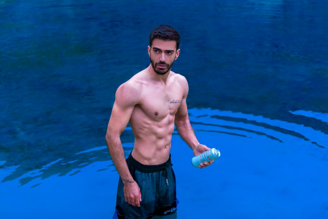 a man in a pool holding a bottle