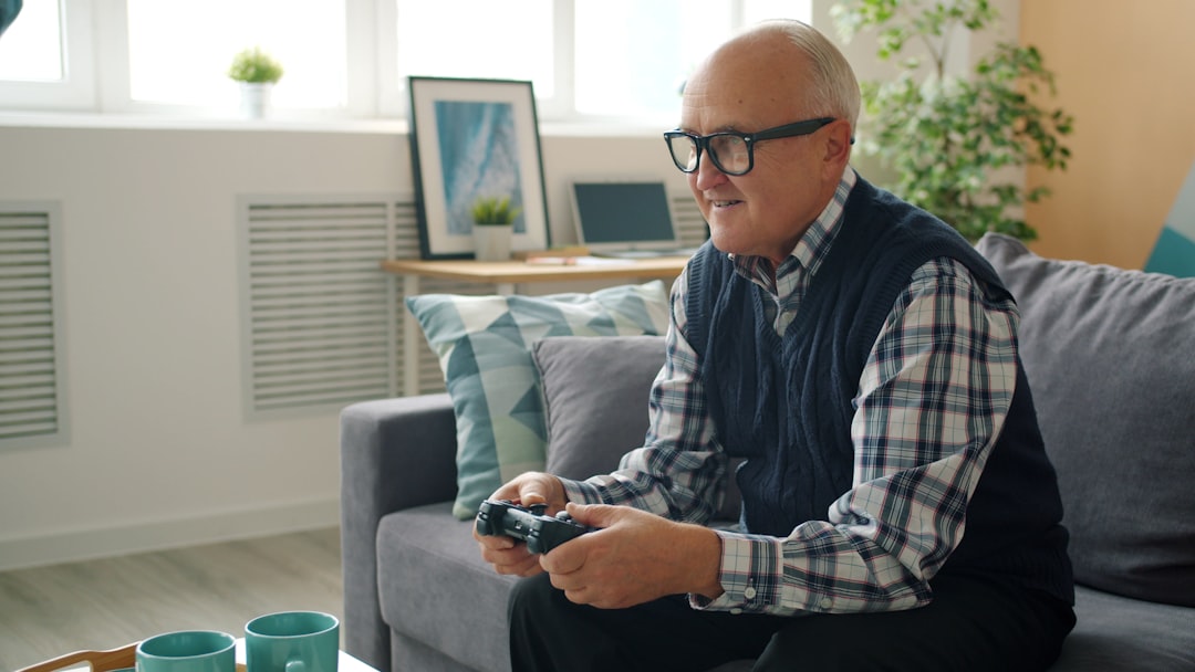 Elderly man playing video games on couch