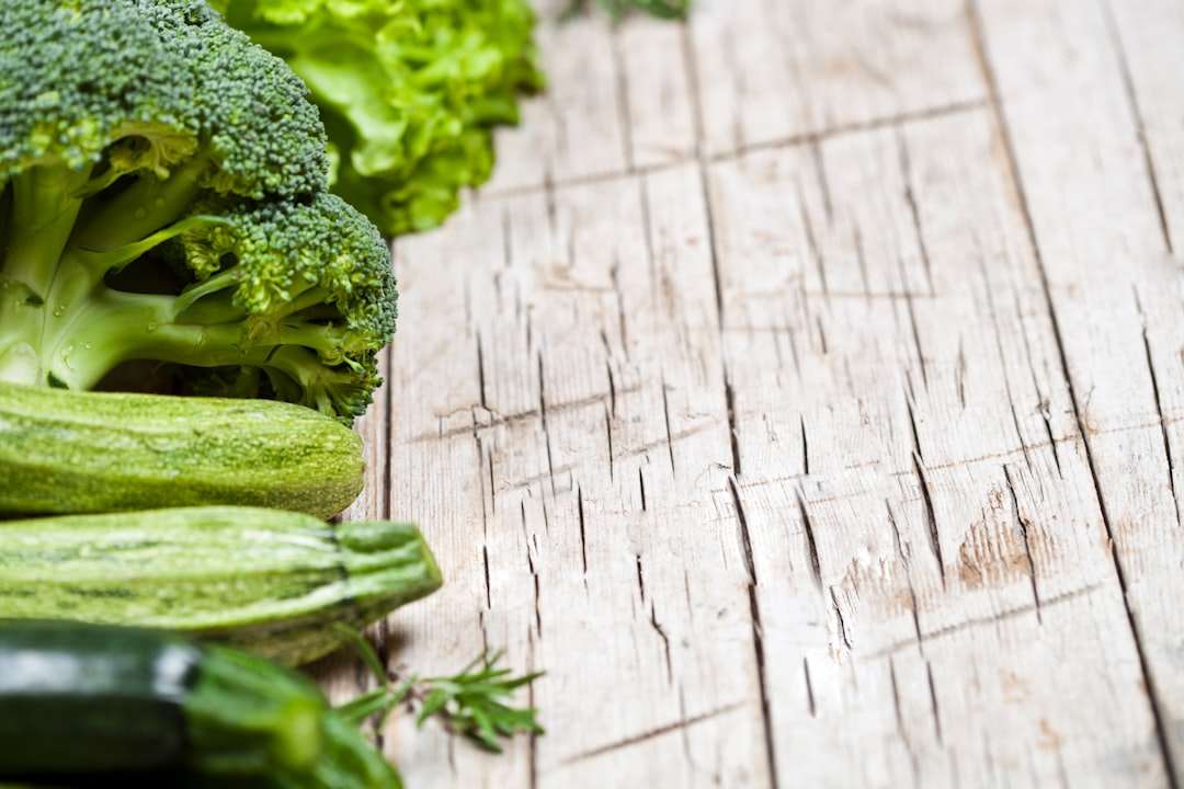 Broccoli and cucumbers are lined up on a table