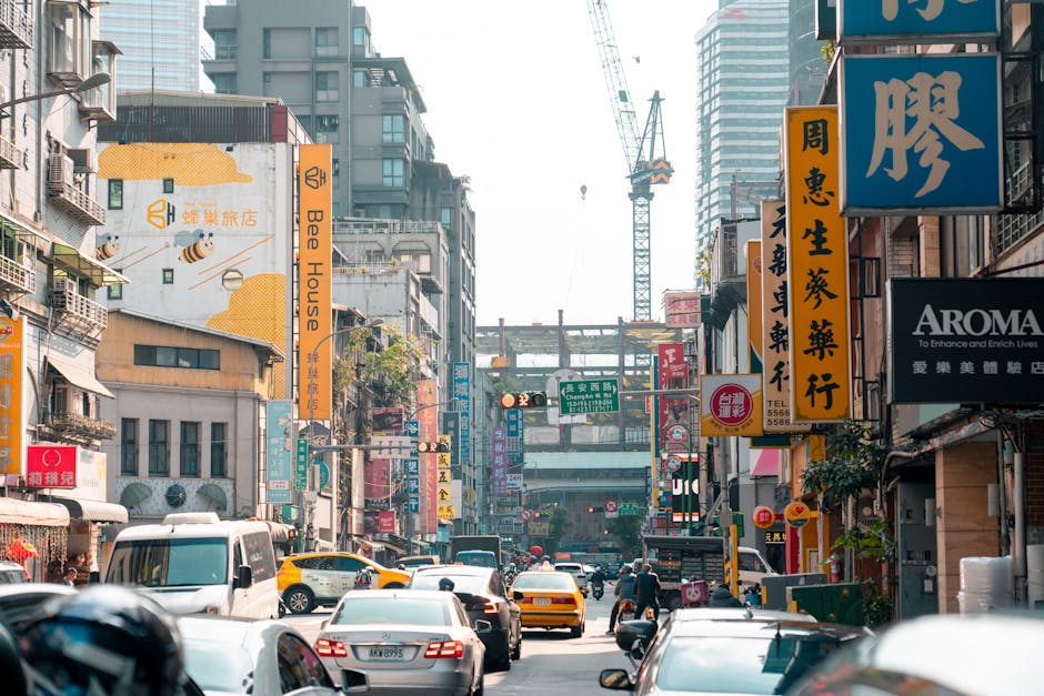 A lively urban street in Taipei, Taiwan, bustling with traffic and colorful signage.