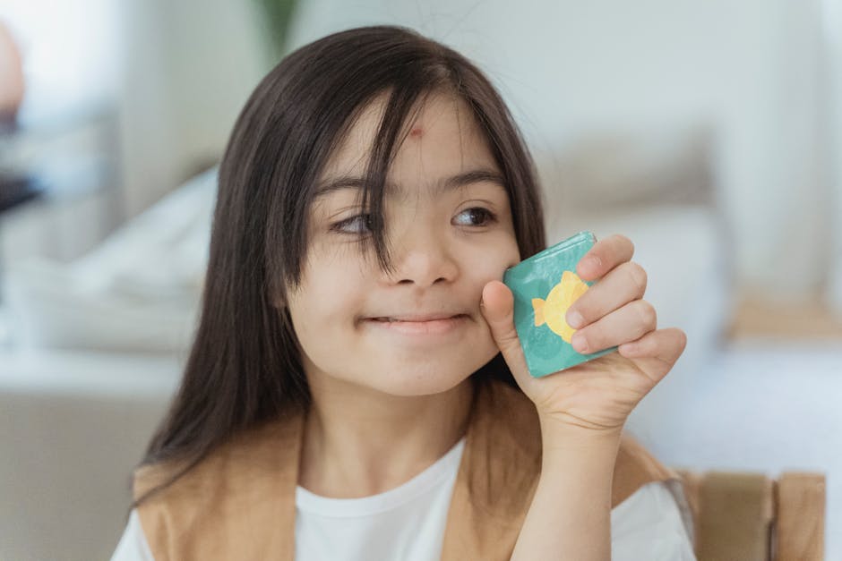 Adorable child indoors, holding a colorful handmade card with a warm smile.