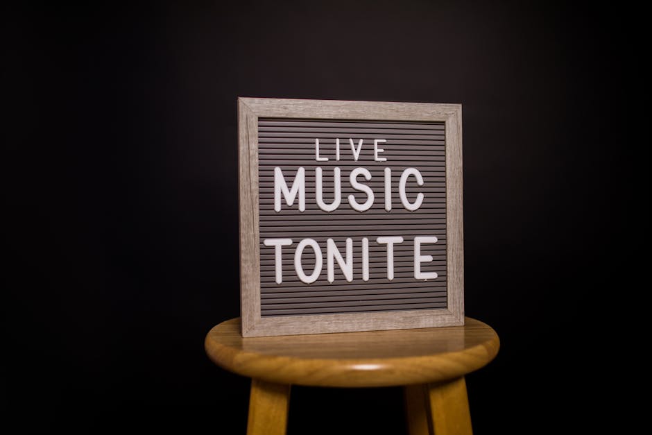 Framed sign announcing live music tonight placed on a wooden stool.