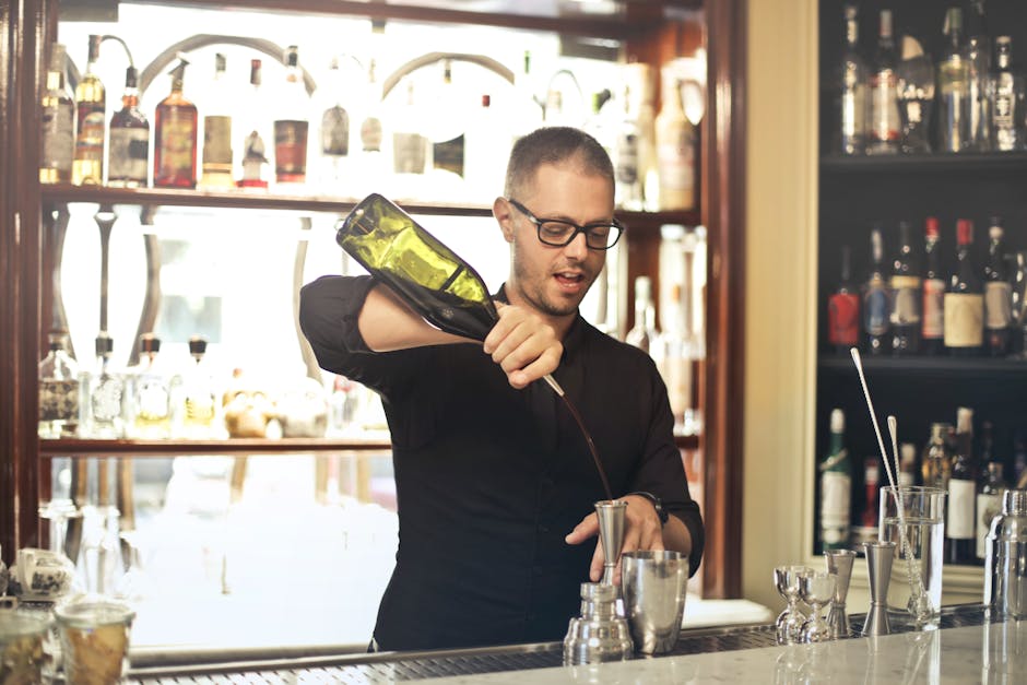 A skilled bartender preparing drinks in a stylish, modern bar setting.