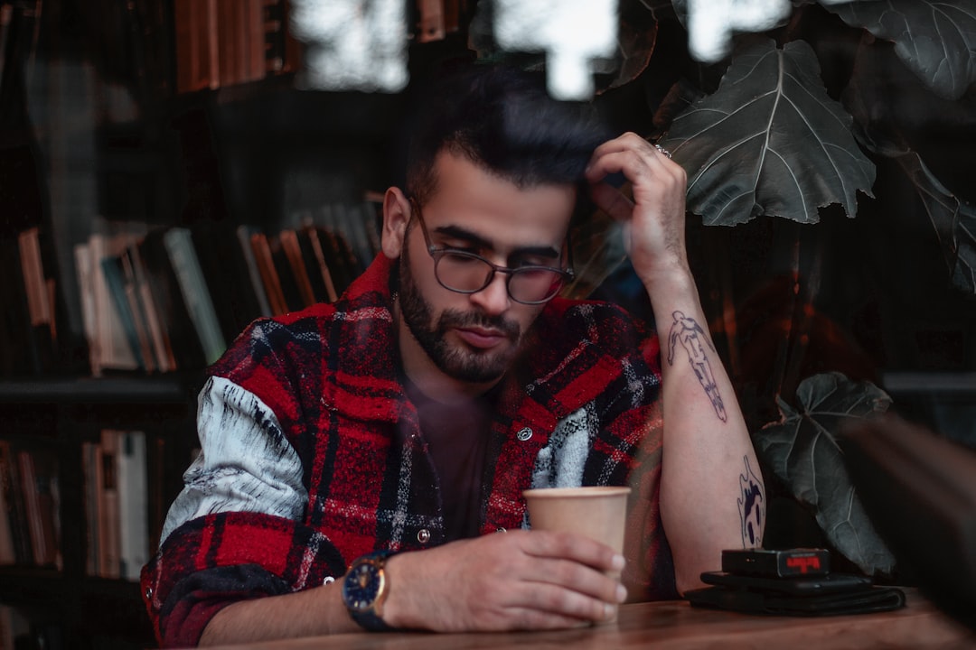 a man sitting at a table with a cup of coffee