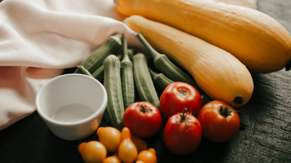 A vibrant array of fresh summer vegetables including squash, okra, and tomatoes.