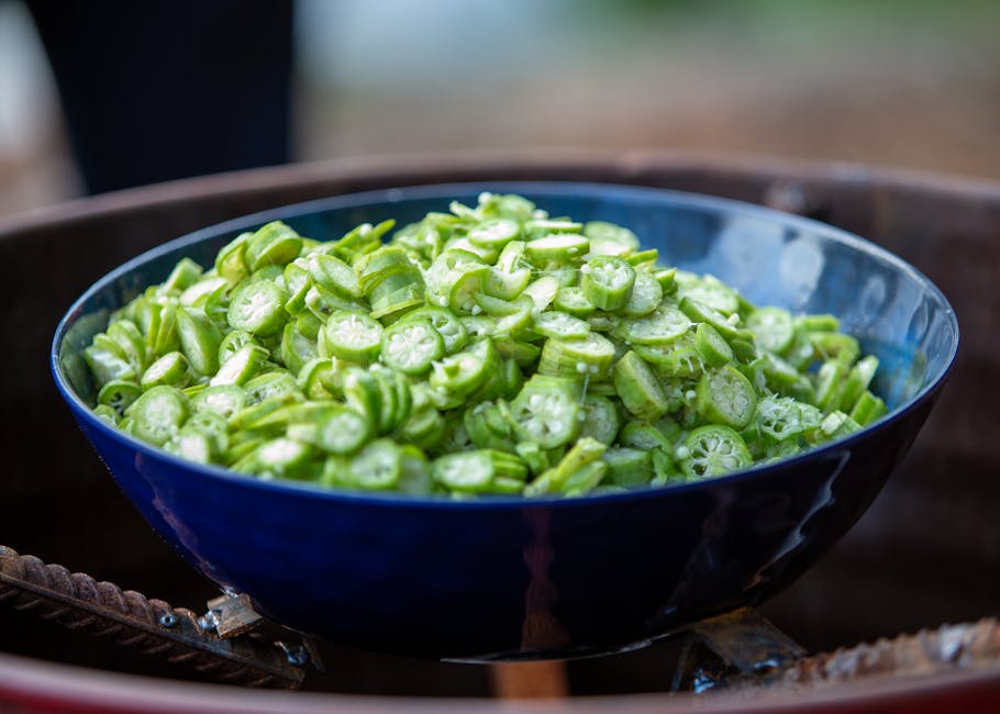 A close-up view of sliced okra in a blue bowl, perfect for cooking inspiration.