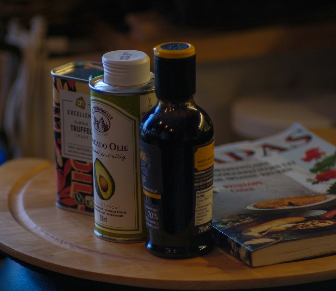A bottle of olive oil and a can of olive oil on a table