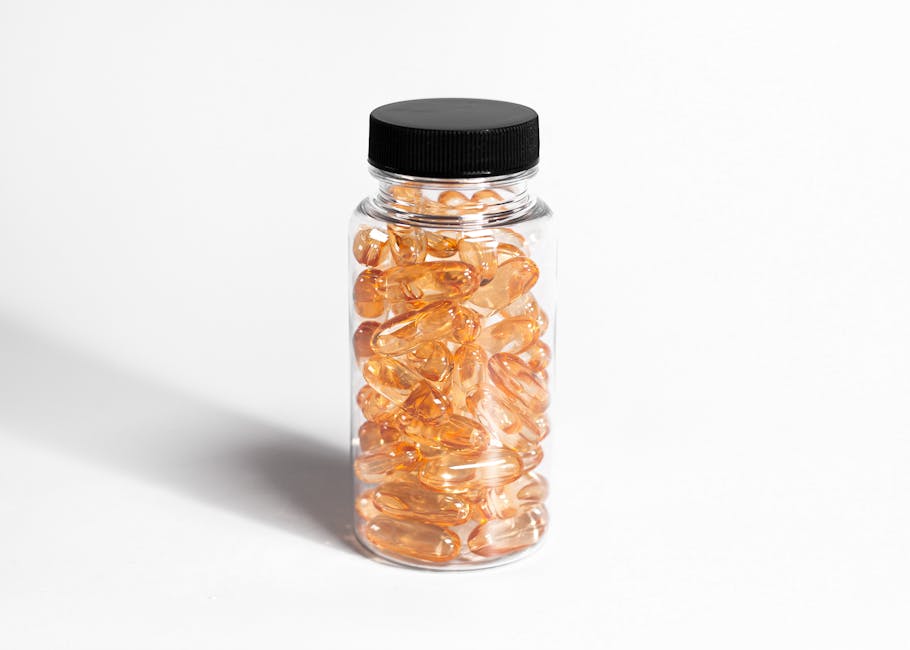 A transparent bottle filled with amber capsules against a white background, showcasing health and nutrition.