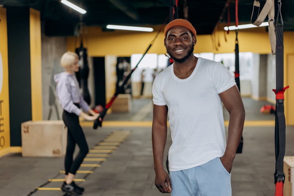 A smiling African American man in a modern gym, exemplifying fitness and health lifestyle.
